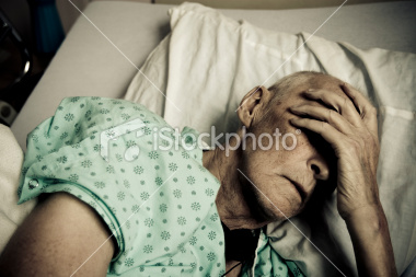 ist2_8259074-sick-and-senior-man-wearing-hospitable-gown-lying-in-bed